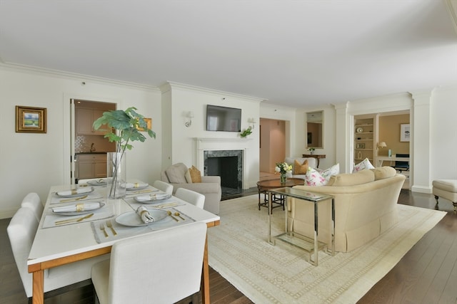 living room with ornamental molding, a premium fireplace, dark wood-type flooring, and sink