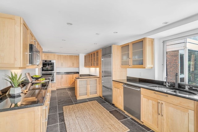 kitchen with plenty of natural light, sink, dark tile patterned flooring, and stainless steel appliances