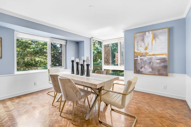 dining space with ornamental molding and light parquet floors