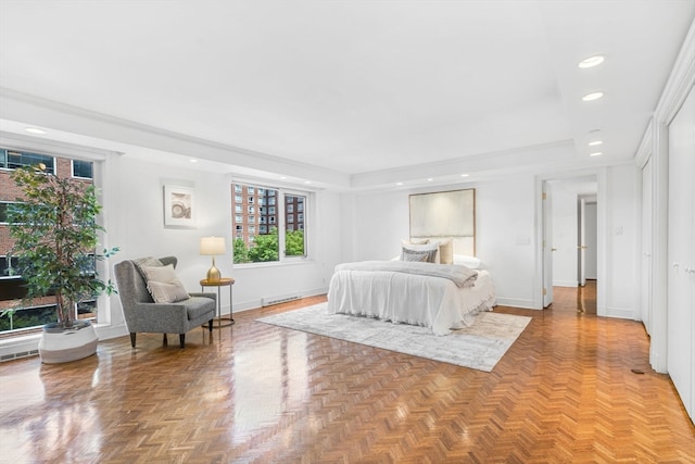 bedroom featuring a baseboard heating unit, a raised ceiling, and parquet floors