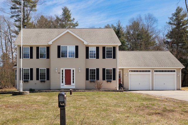 colonial home featuring a front yard and a garage