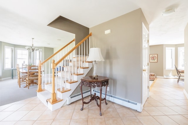 staircase with a baseboard heating unit, a notable chandelier, and light tile flooring