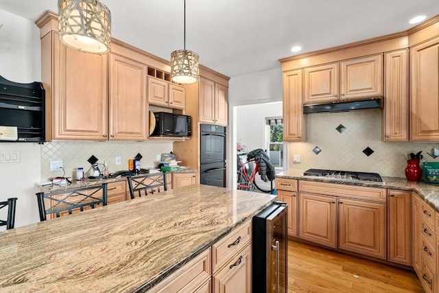 379 Hunnewell St, Needham, MA 02494 - kitchen with beverage cooler, black appliances, light stone counters, light wood-style flooring, and under cabinet range hood