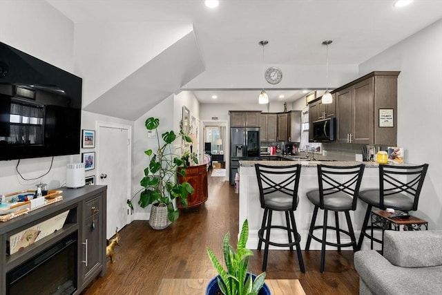 379 Hunnewell St, Needham, MA 02494 - kitchen with stainless steel microwave, a peninsula, dark brown cabinets, fridge with ice dispenser, and decorative backsplash
