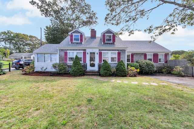 cape cod home with a front lawn