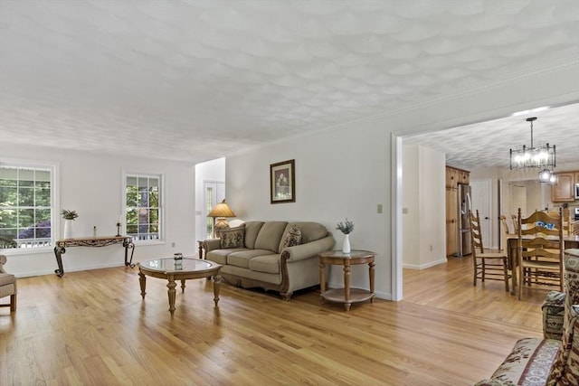 22 Mikayla Ann Dr, Rehoboth, MA 02769 - living room with light wood-style floors, a chandelier, and baseboards