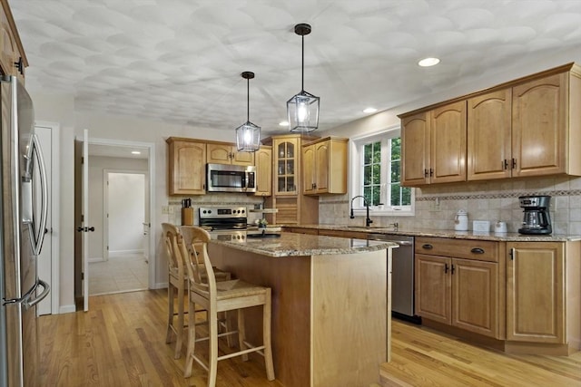 22 Mikayla Ann Dr, Rehoboth, MA 02769 - kitchen featuring stainless steel appliances, a sink, light stone counters, a breakfast bar area, and a center island