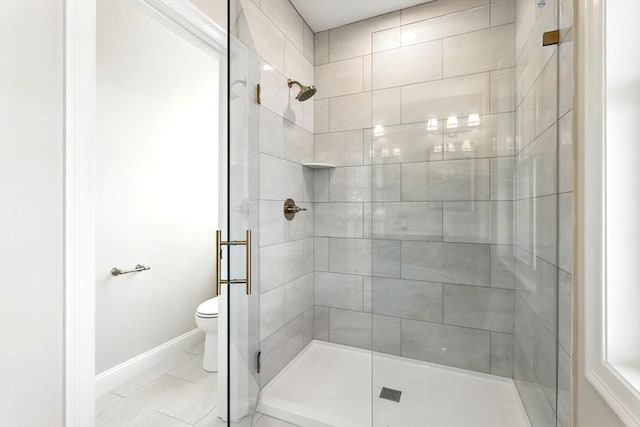 full bathroom featuring a shower stall, toilet, and baseboards