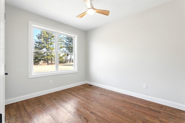 spare room with a ceiling fan, wood finished floors, and baseboards