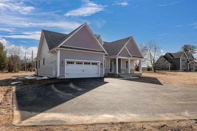 craftsman inspired home with aphalt driveway, a garage, and covered porch