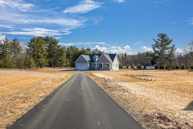 view of front facade with aphalt driveway and a garage