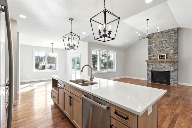 kitchen with a sink, dark wood-type flooring, light countertops, stainless steel dishwasher, and a chandelier