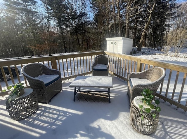 snow covered deck featuring a shed