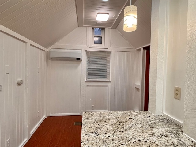 spacious closet featuring dark wood-type flooring, lofted ceiling, and an AC wall unit