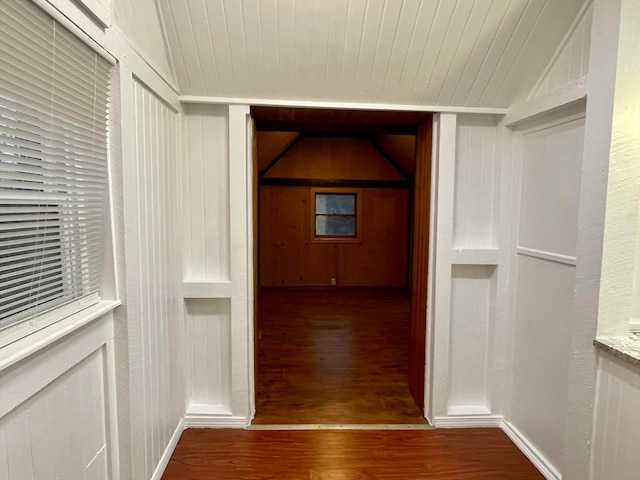 hallway featuring hardwood / wood-style floors, wood ceiling, vaulted ceiling, and built in shelves