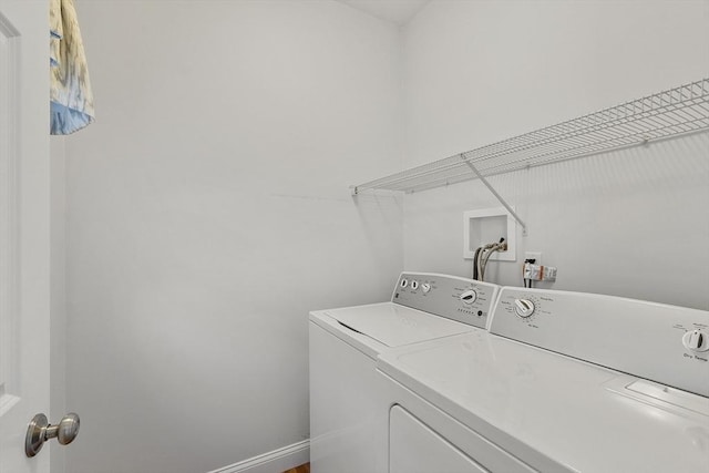 washroom featuring laundry area, washing machine and dryer, and baseboards