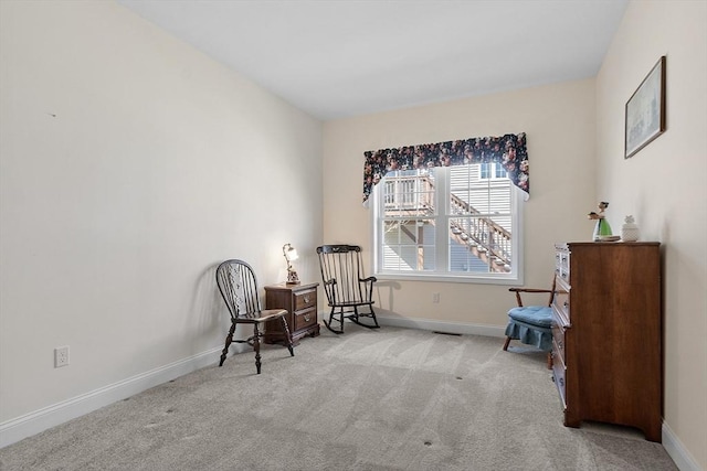 living area featuring carpet flooring and baseboards