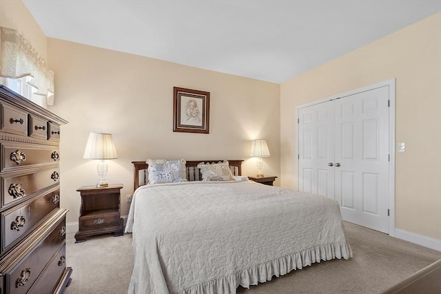 bedroom featuring a closet, baseboards, and light colored carpet