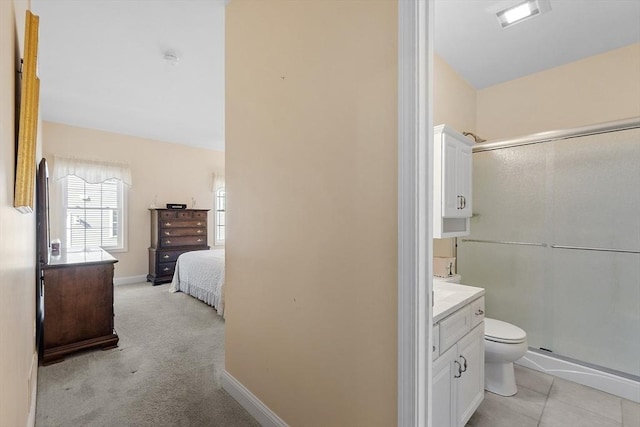 bathroom featuring baseboards, toilet, a stall shower, tile patterned floors, and vanity