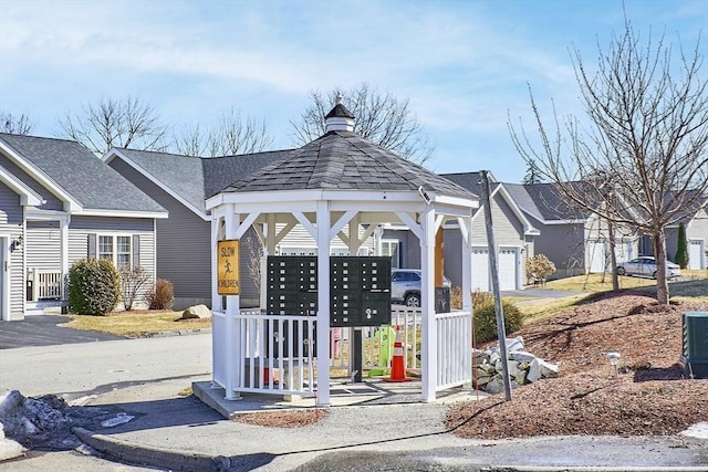 surrounding community with a gazebo, mail area, and a garage