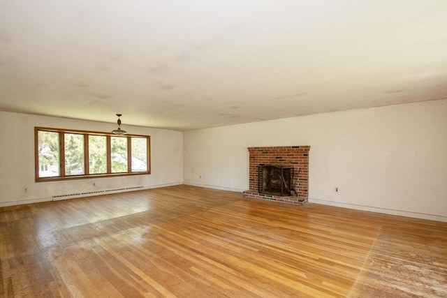 unfurnished living room featuring a baseboard radiator, light wood-type flooring, baseboards, and a brick fireplace