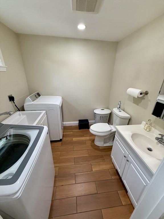 21 Florence Ave, Lowell, MA 01851 - bathroom with separate washer and dryer, toilet, vanity, recessed lighting, and wood tiled floors