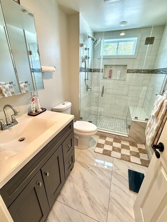 21 Florence Ave, Lowell, MA 01851 - full bathroom featuring vanity, toilet, a shower stall, and marble finish floors