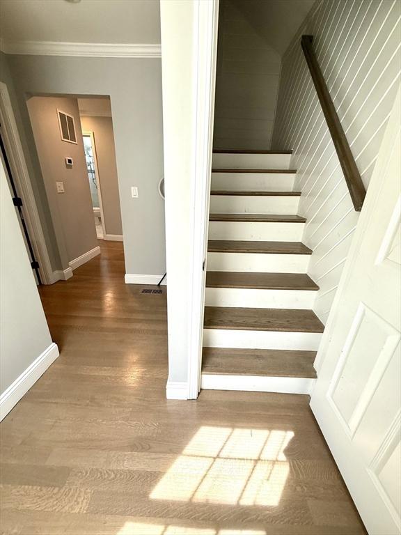 21 Florence Ave, Lowell, MA 01851 - staircase featuring baseboards, wood finished floors, and ornamental molding