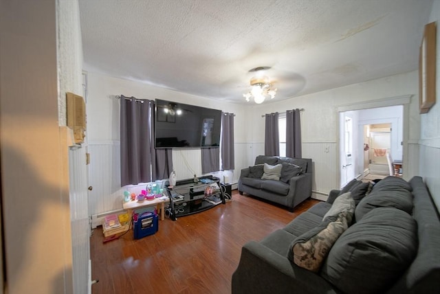 42 Morton St, Lawrence, MA 01841 - living area with wood finished floors, wainscoting, baseboard heating, and a textured ceiling