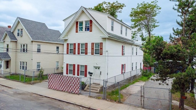 42 Morton St, Lawrence, MA 01841 - view of front of home with a gate, a fenced front yard, and roof with shingles