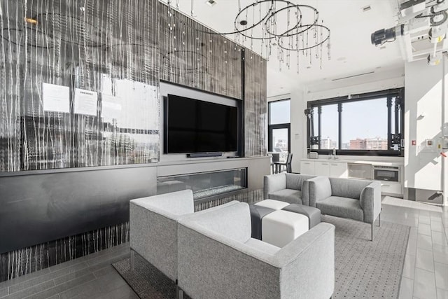 living room featuring a glass covered fireplace and an inviting chandelier