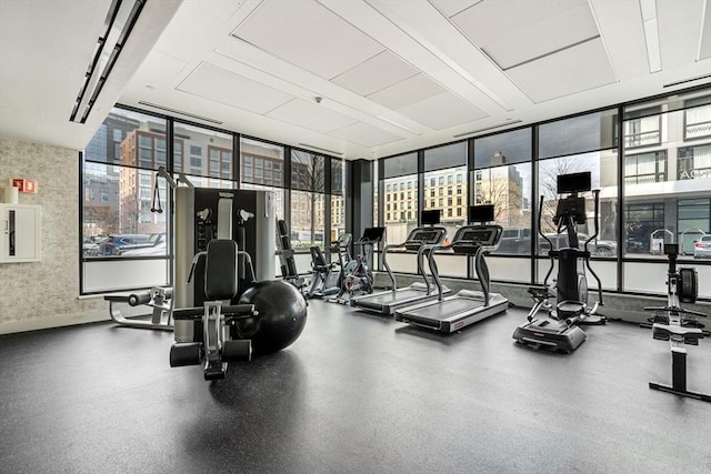 workout area with baseboards, floor to ceiling windows, and wallpapered walls