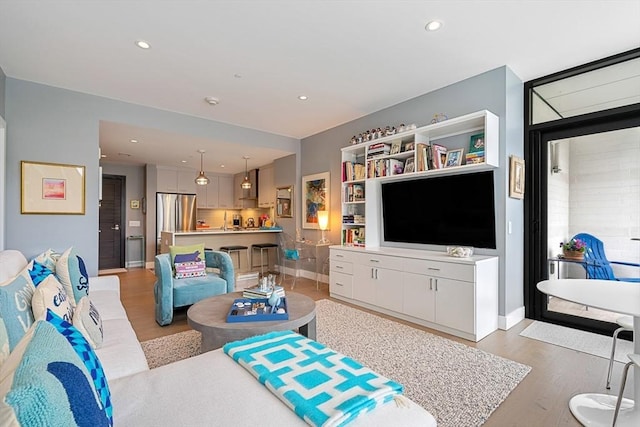 living area featuring recessed lighting, baseboards, and wood finished floors