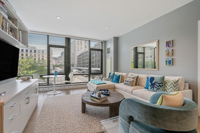 living area with a wall of windows, a view of city, visible vents, and plenty of natural light