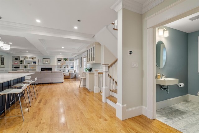 foyer featuring light hardwood / wood-style flooring, beam ceiling, coffered ceiling, and crown molding