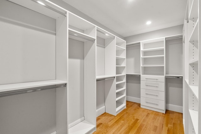 walk in closet with light hardwood / wood-style floors