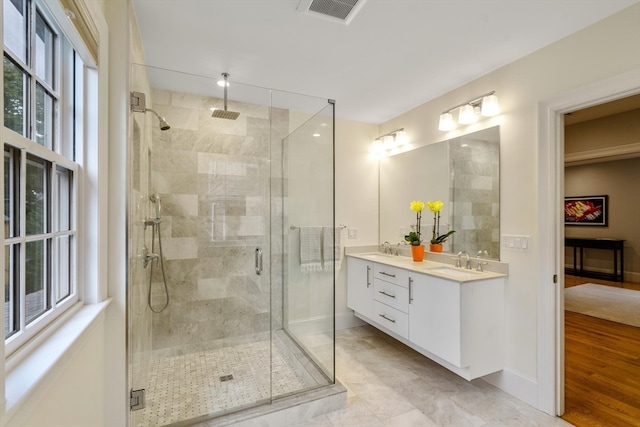 bathroom with wood-type flooring, vanity, and a shower with door