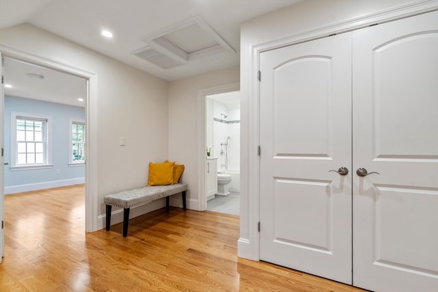 hall with lofted ceiling and light hardwood / wood-style floors