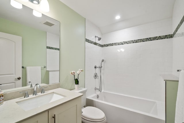 full bathroom featuring vanity, tiled shower / bath combo, and toilet