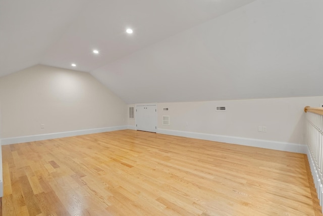 bonus room with vaulted ceiling and light hardwood / wood-style floors