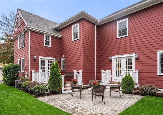 rear view of house featuring central AC unit, a lawn, and a patio