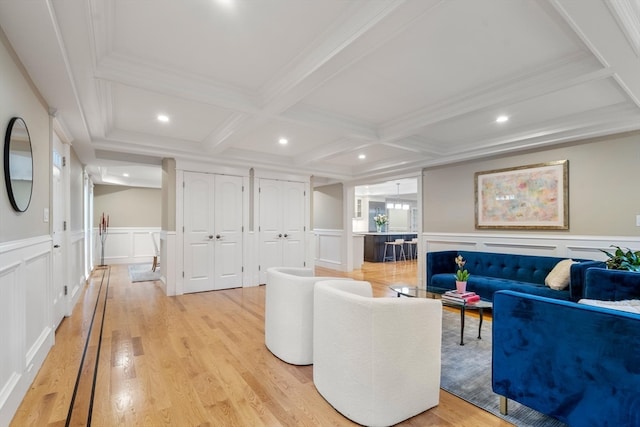 living room with crown molding, light hardwood / wood-style floors, beam ceiling, and coffered ceiling