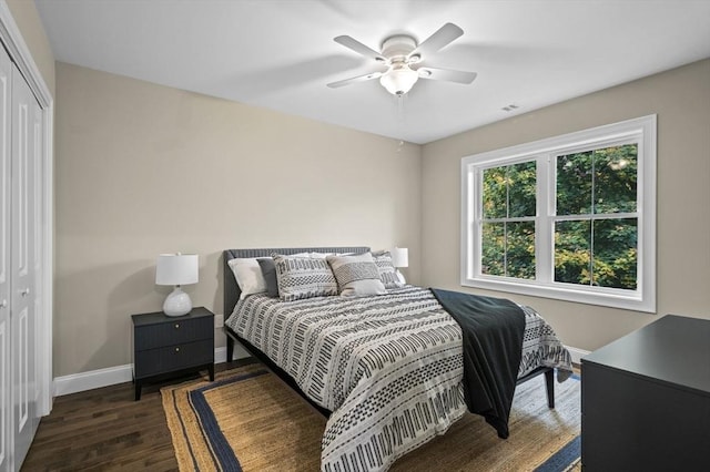 bedroom featuring visible vents, baseboards, a ceiling fan, wood finished floors, and a closet