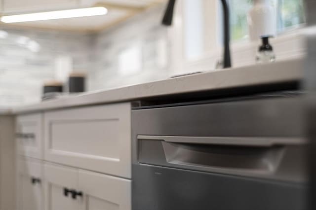 interior space featuring white cabinets and dishwasher