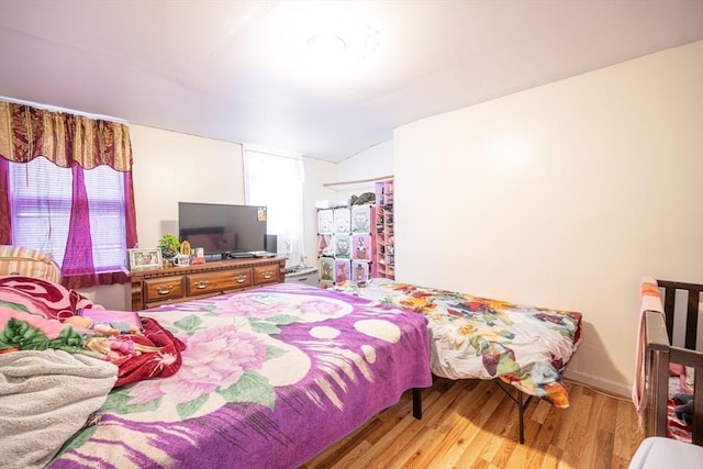 bedroom with lofted ceiling and light hardwood / wood-style floors