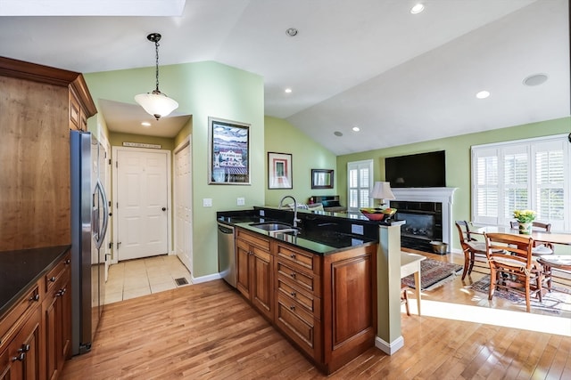 kitchen featuring kitchen peninsula, light hardwood / wood-style floors, sink, and lofted ceiling