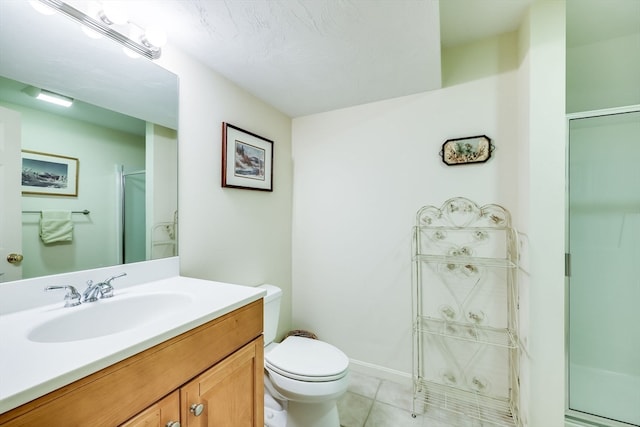 bathroom with toilet, vanity, tile patterned flooring, and walk in shower