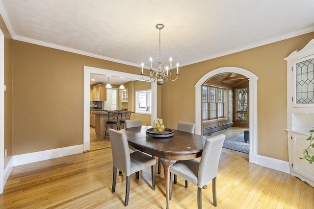 26 Edgewood Ave, Longmeadow, MA 01106 - dining room featuring arched walkways, light wood-style flooring, baseboards, a chandelier, and crown molding