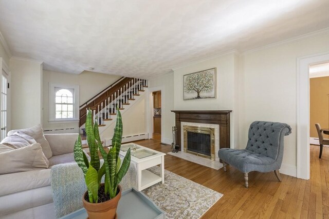 26 Edgewood Ave, Longmeadow, MA 01106 - living room with a baseboard radiator, wood finished floors, stairway, ornamental molding, and a fireplace with flush hearth
