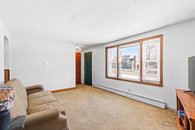 living room with baseboard heating and light colored carpet